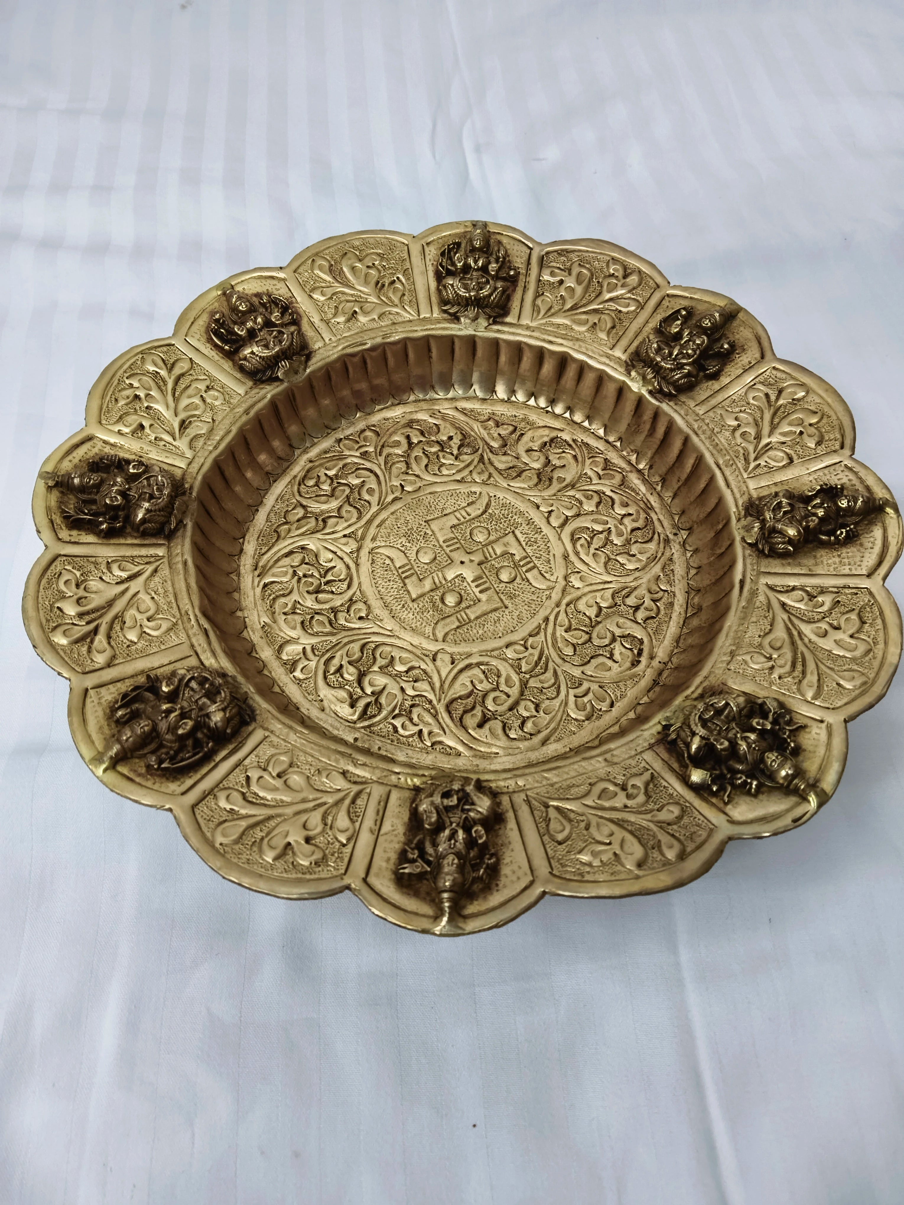 Mini brass decor plate with floral patterns and deity figures around edge
