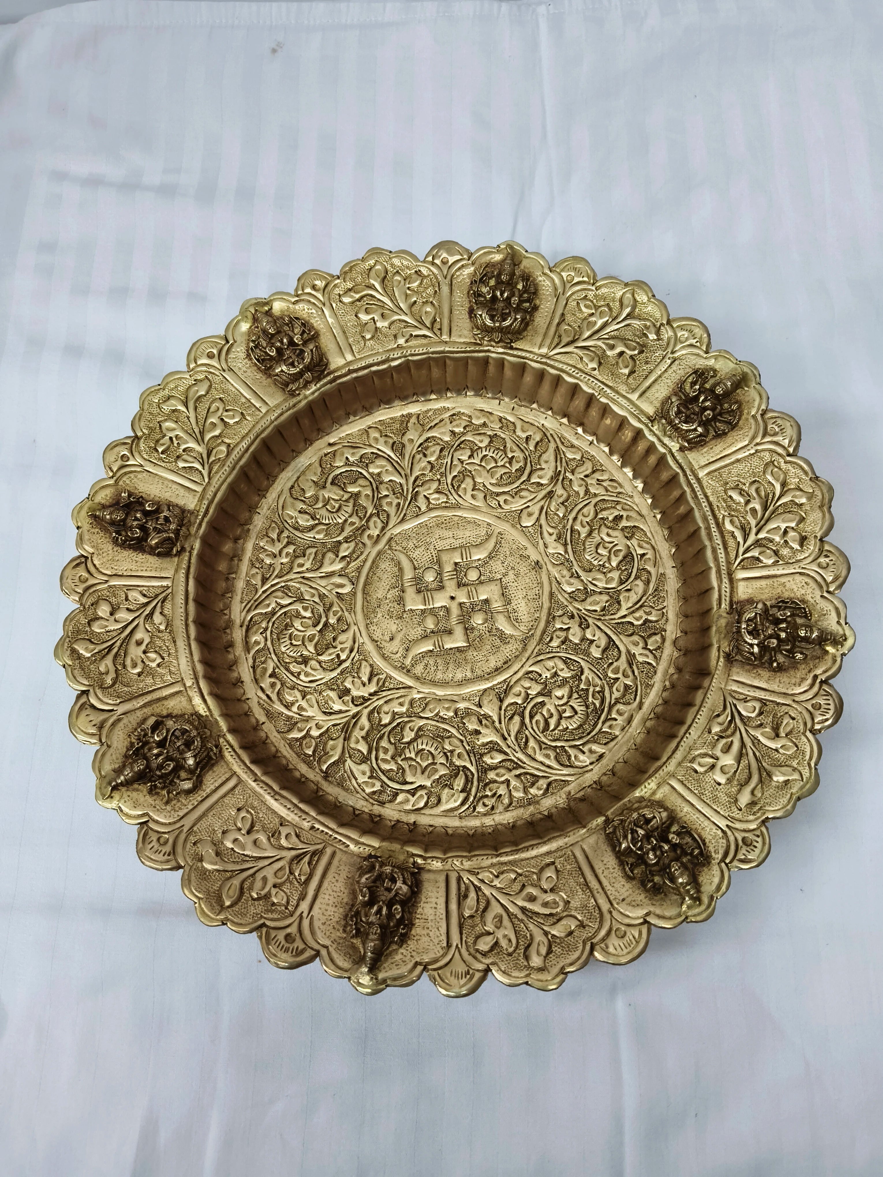Compact round brass decor plate with intricate floral engravings and small figures