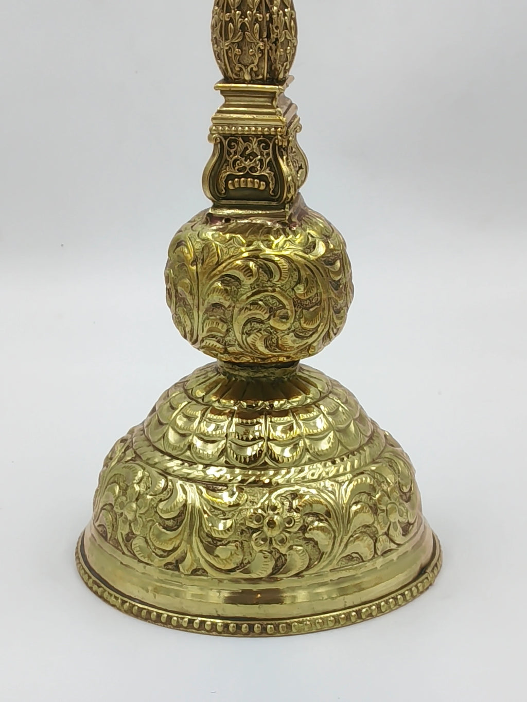 Close-up of intricately engraved brass lamp base with floral and leaf patterns