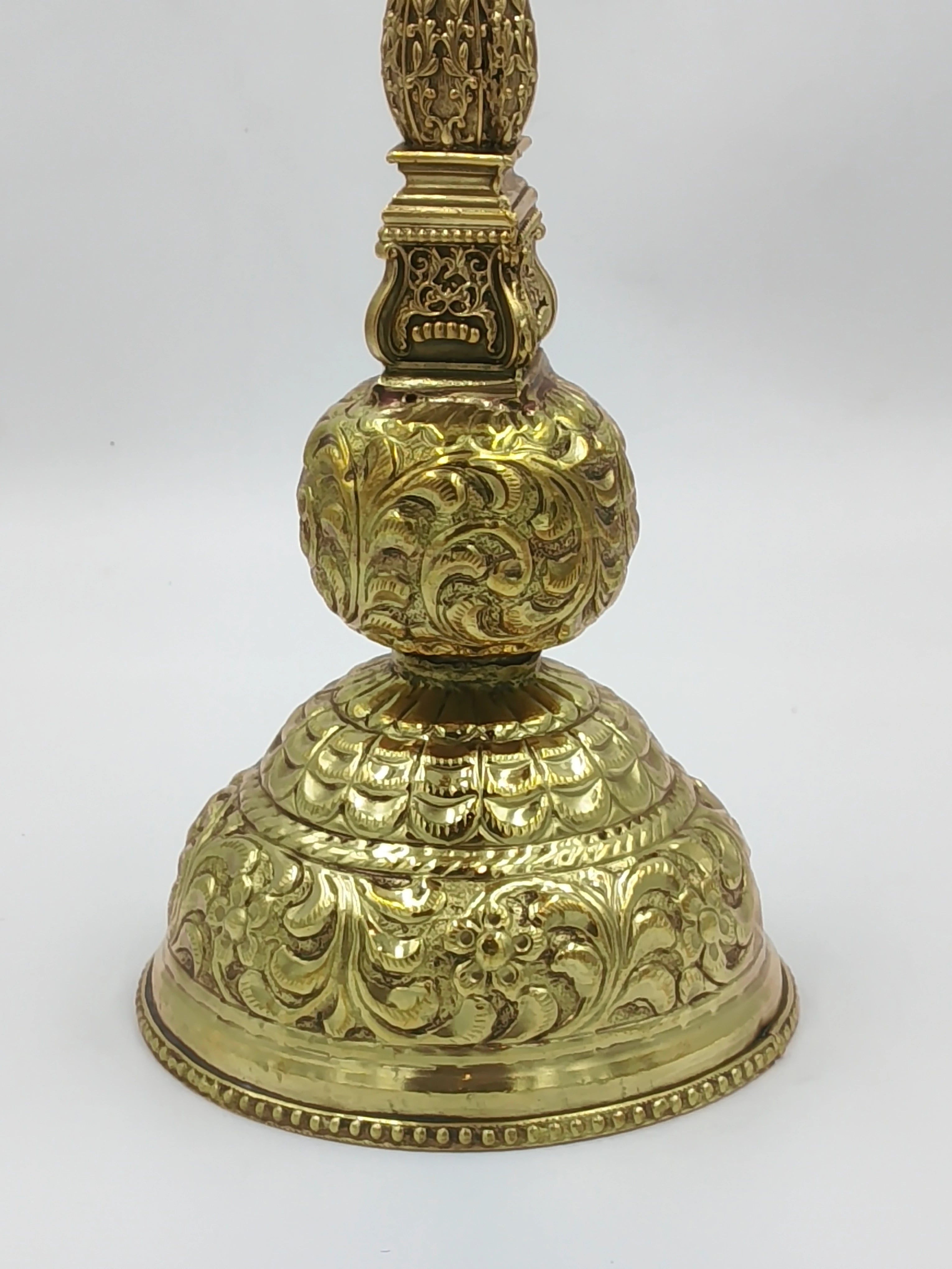 Close-up of intricately engraved brass lamp base with floral and leaf patterns