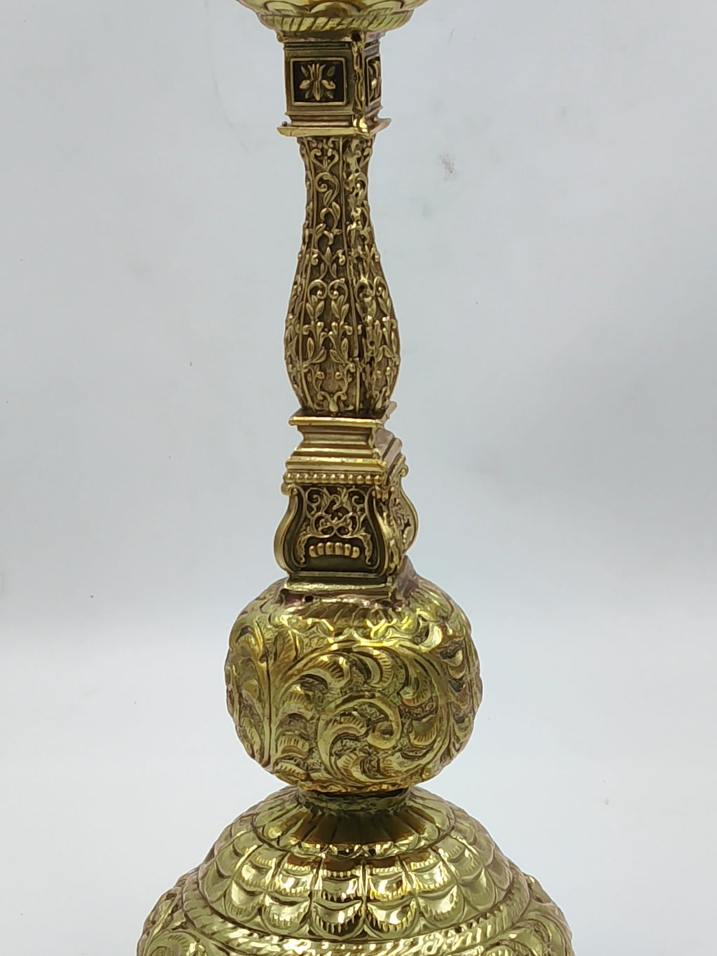 Close-up of a large brass lamp with intricate floral engravings