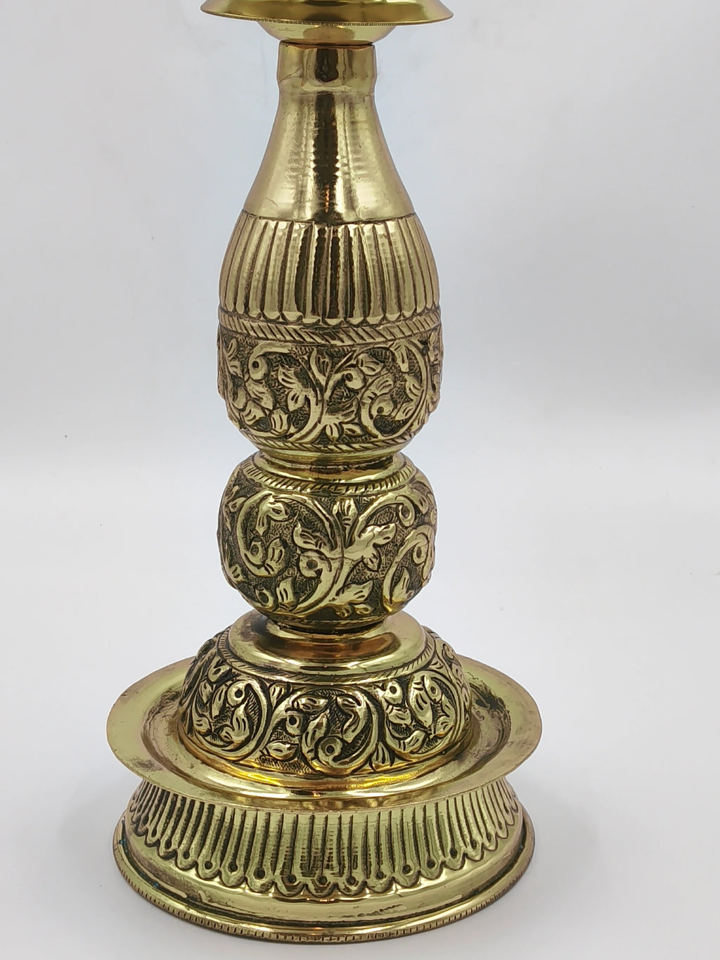 Large brass lamp with intricate floral engravings and polished finish