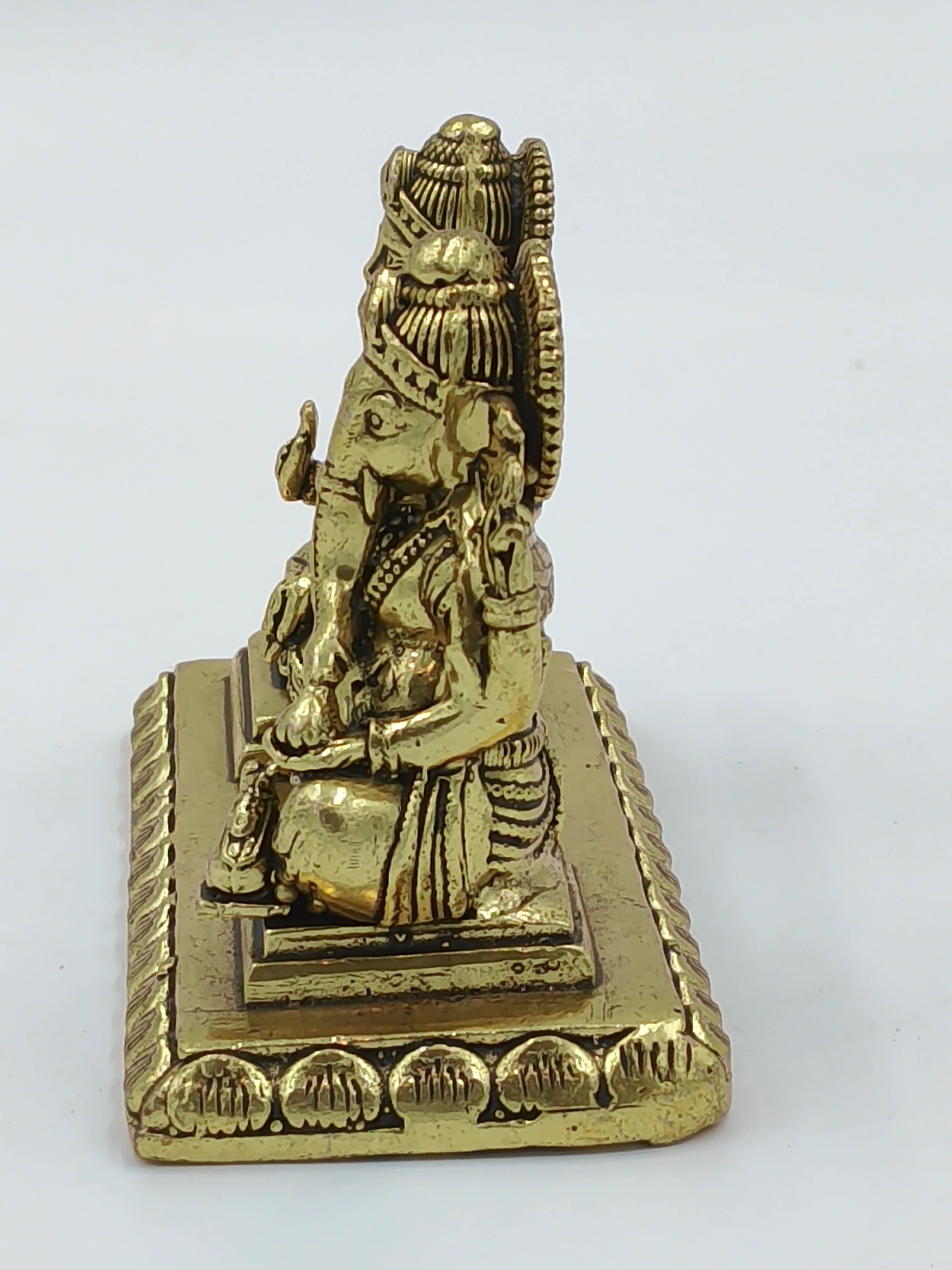 Small brass sculpture of Lakshmi and Ganesh seated together on a rectangular base side view