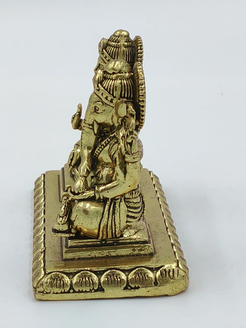 Small brass sculpture of Lakshmi and Ganesh seated together on a rectangular base side view