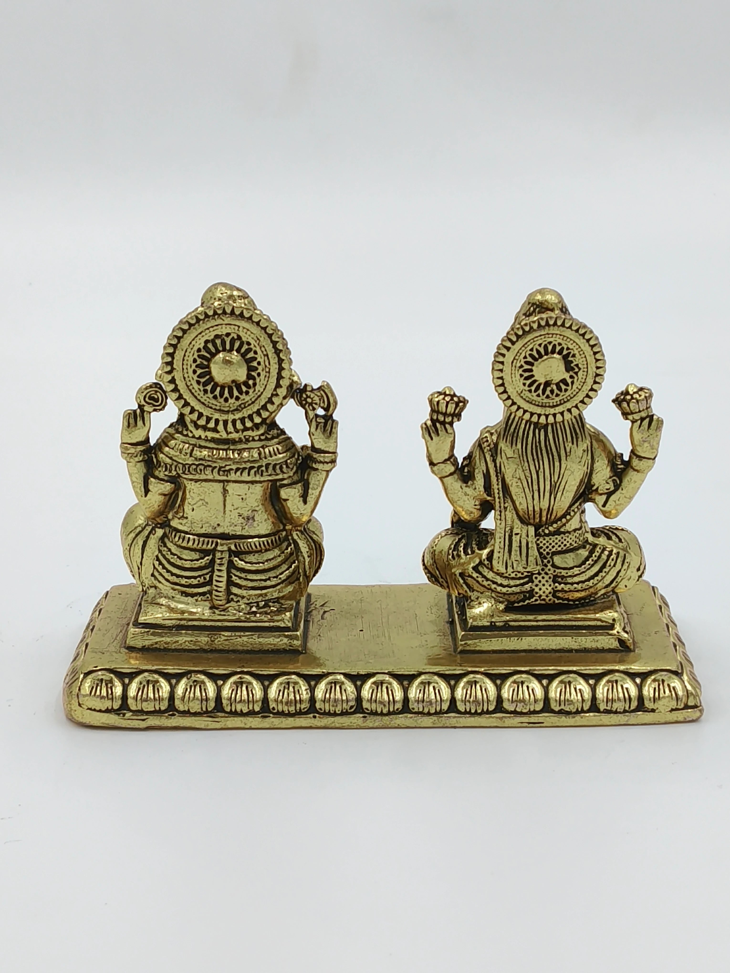 Back view of small brass Lakshmi and Ganesh statues on a decorative base