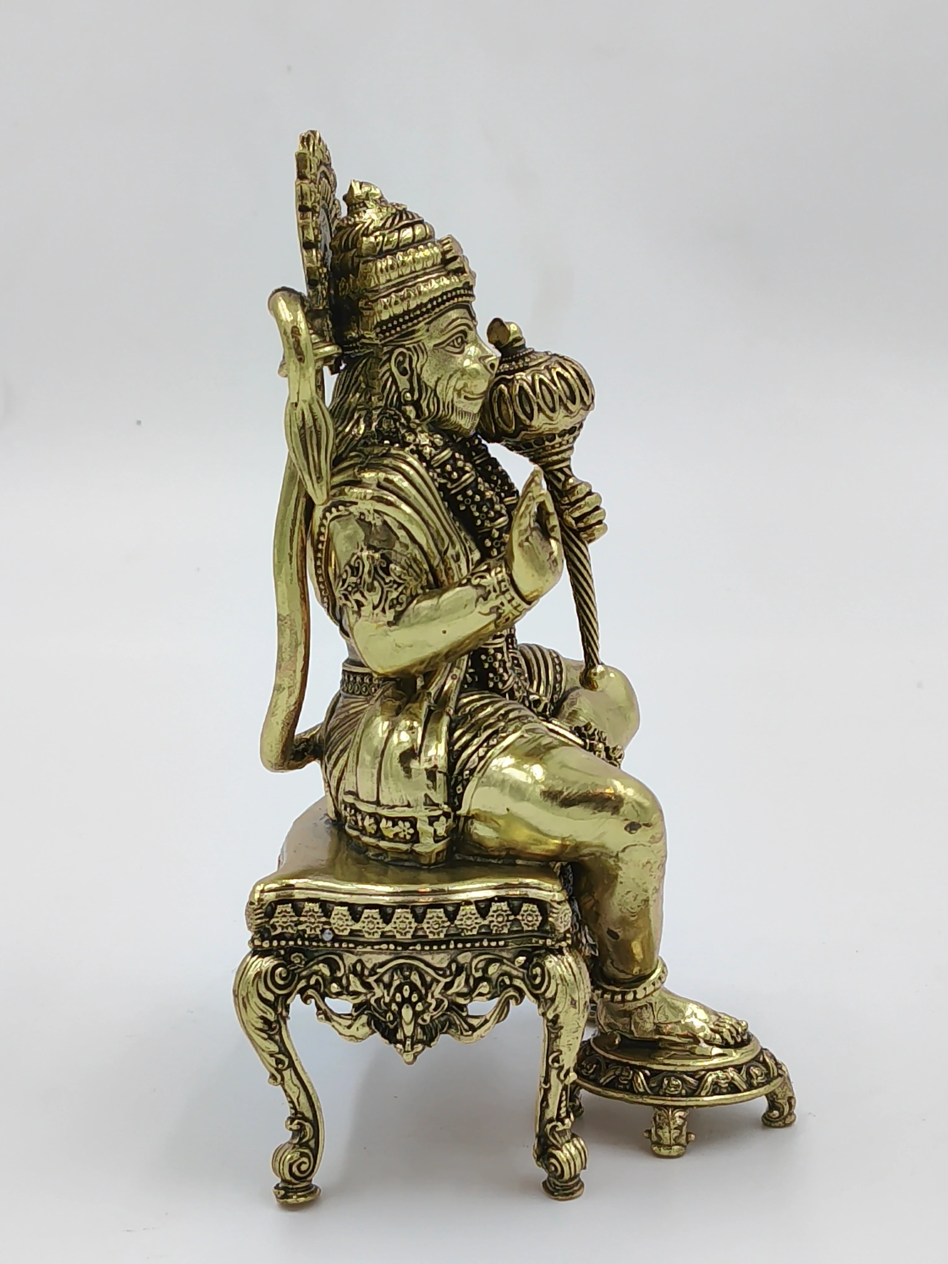 Brass sculpture of Hanuman sitting on an ornate chowki with mace