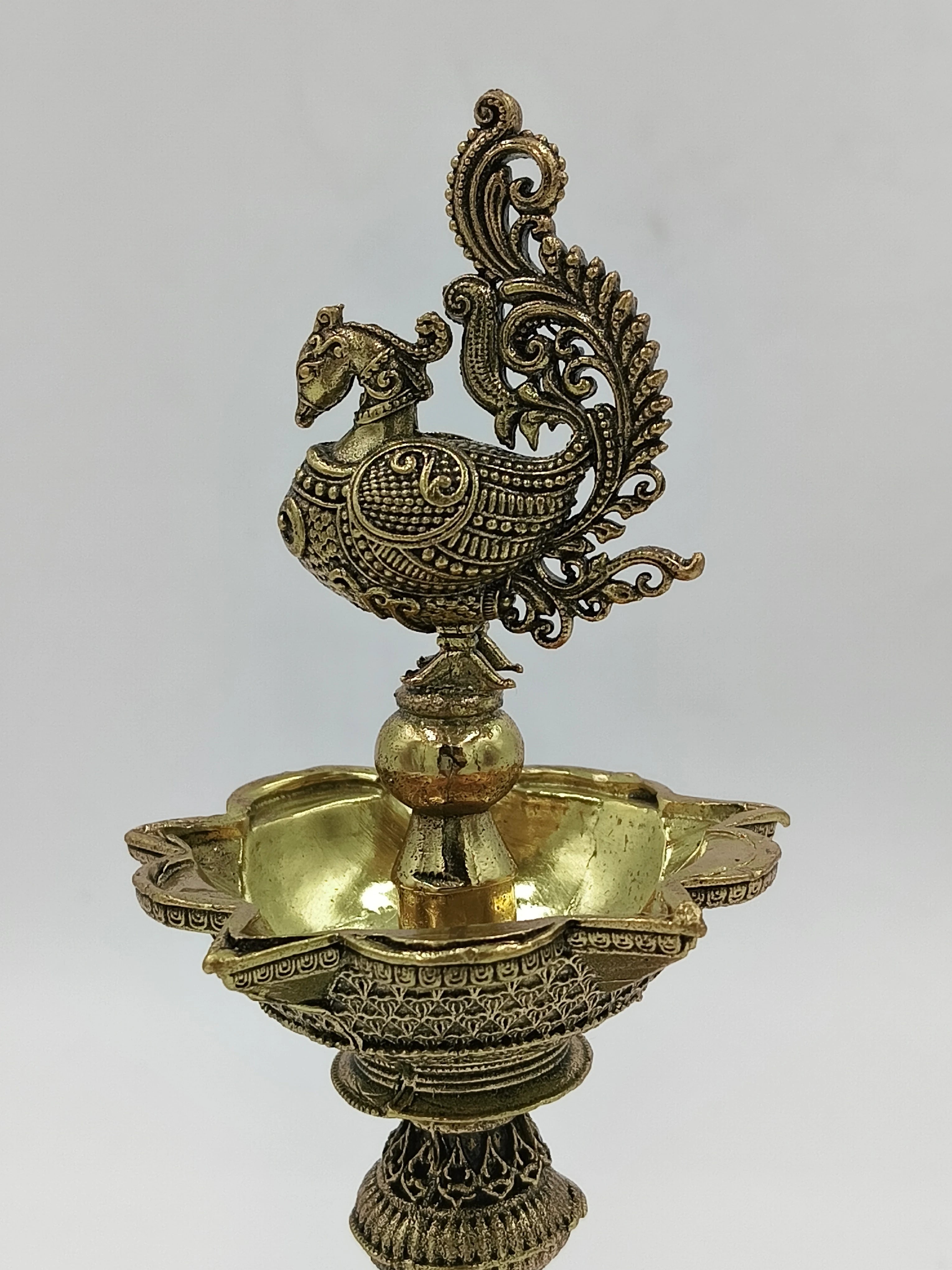 Ornate brass lamp with detailed bird figure and floral patterns