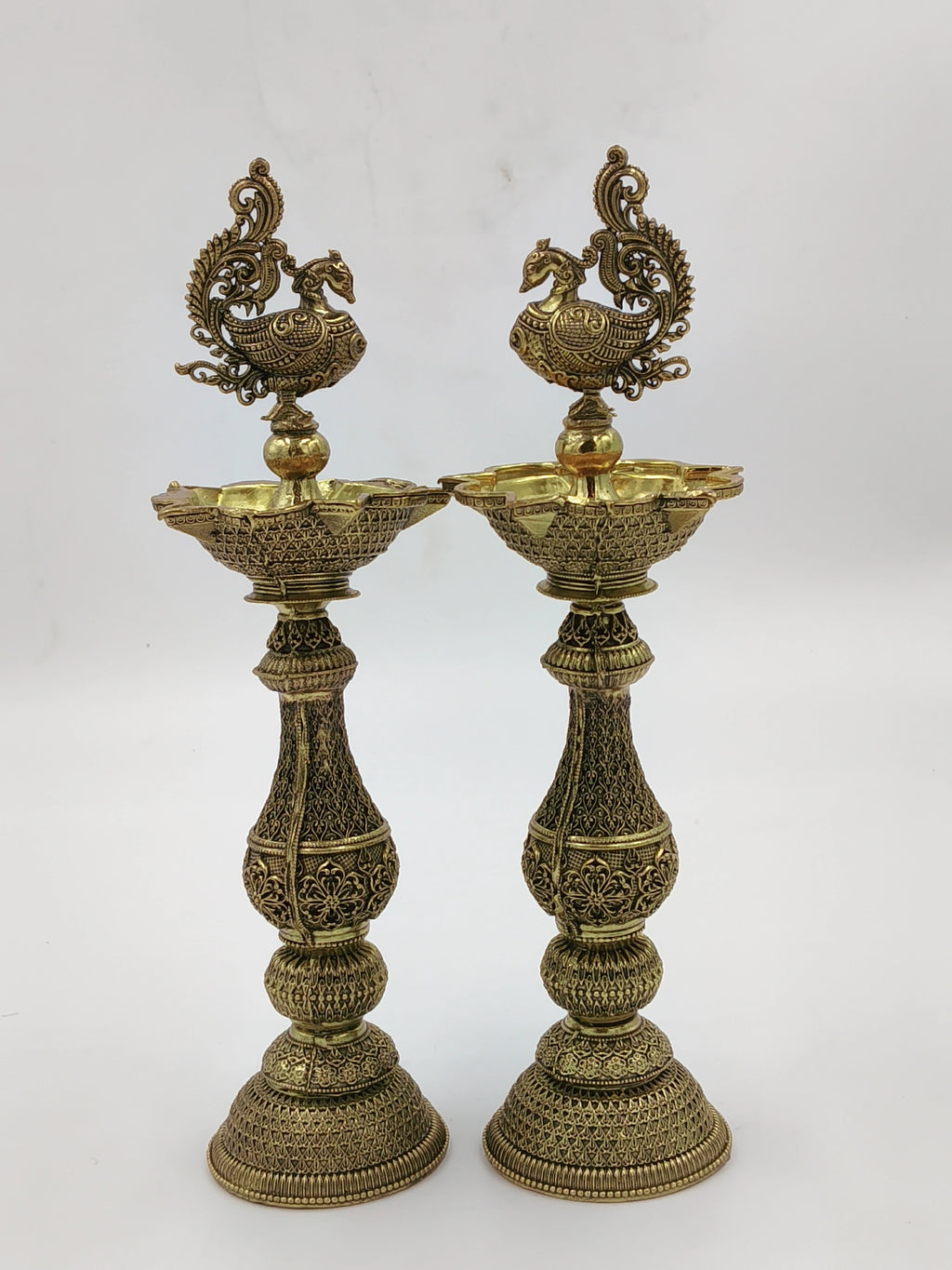 Pair of large brass decorative lamps with intricate peacock designs