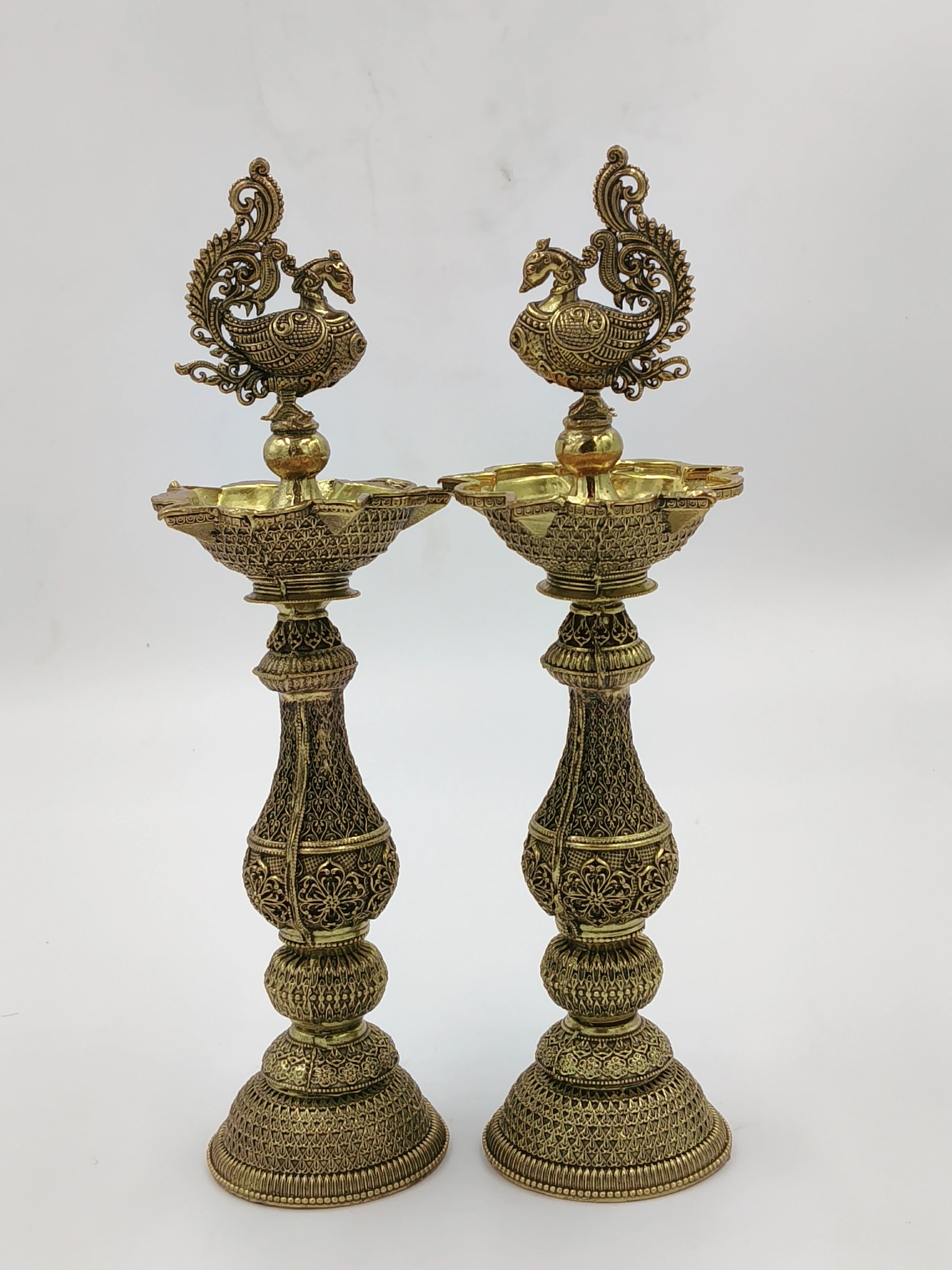 Pair of large brass decorative lamps with intricate peacock designs