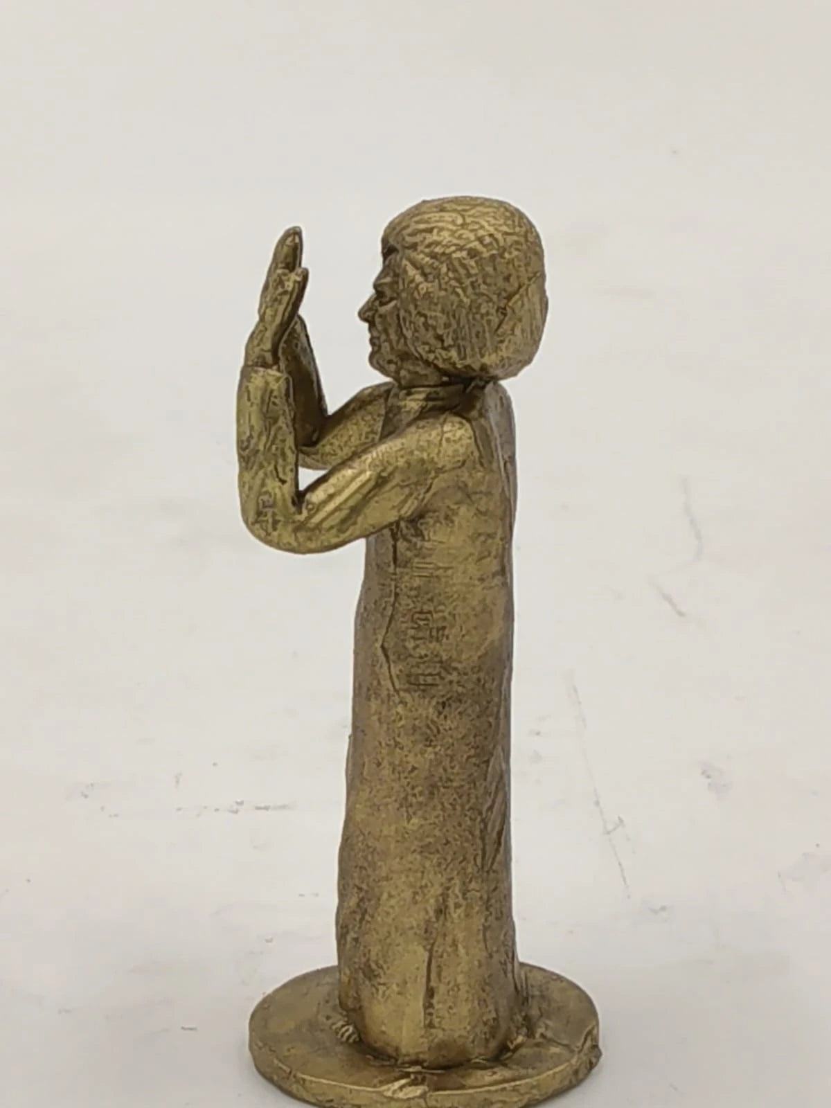 Side view of small brass Sai Baba statue with hands raised in blessing