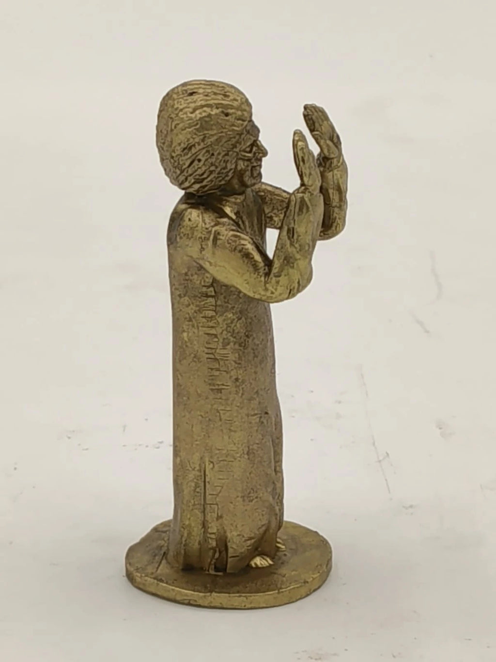 Small brass Sai Baba sculpture with raised hands on round base