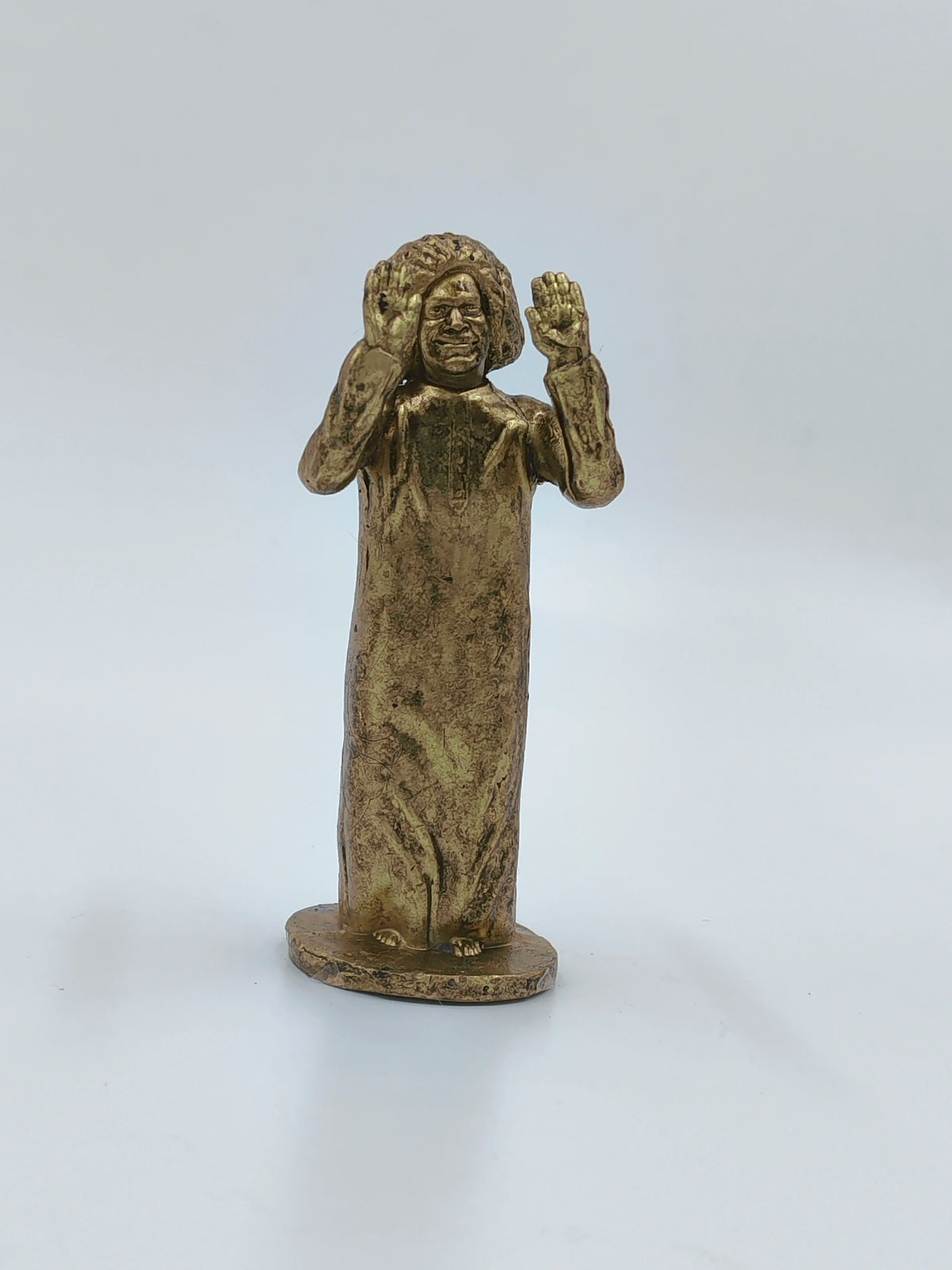 Small brass Sai Baba statue with raised hands on a flat base