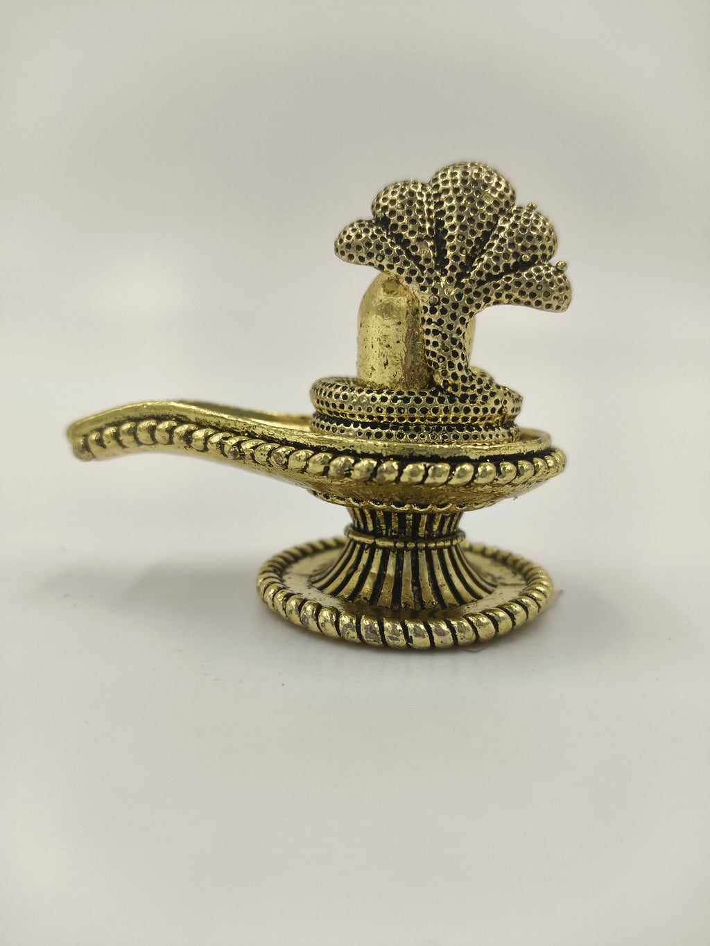 Compact brass shivalinga sculpture with textured snake hood and detailed base