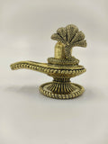 Compact brass shivalinga sculpture with textured snake hood and detailed base