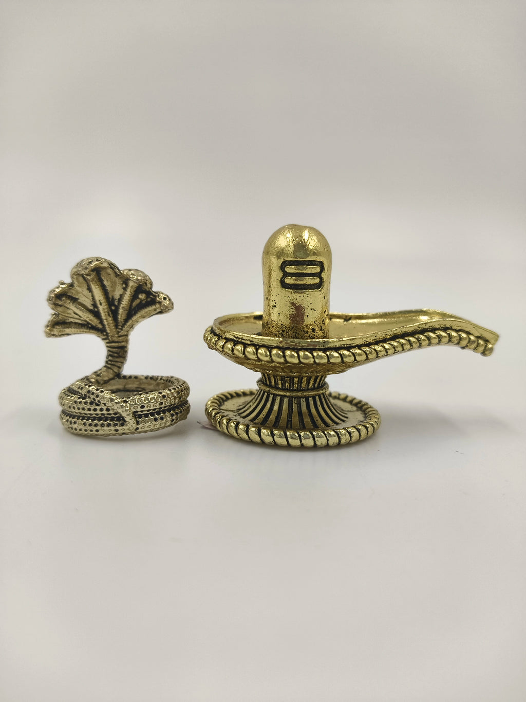 Compact brass Shivalinga sculpture with decorative base and snake figurine