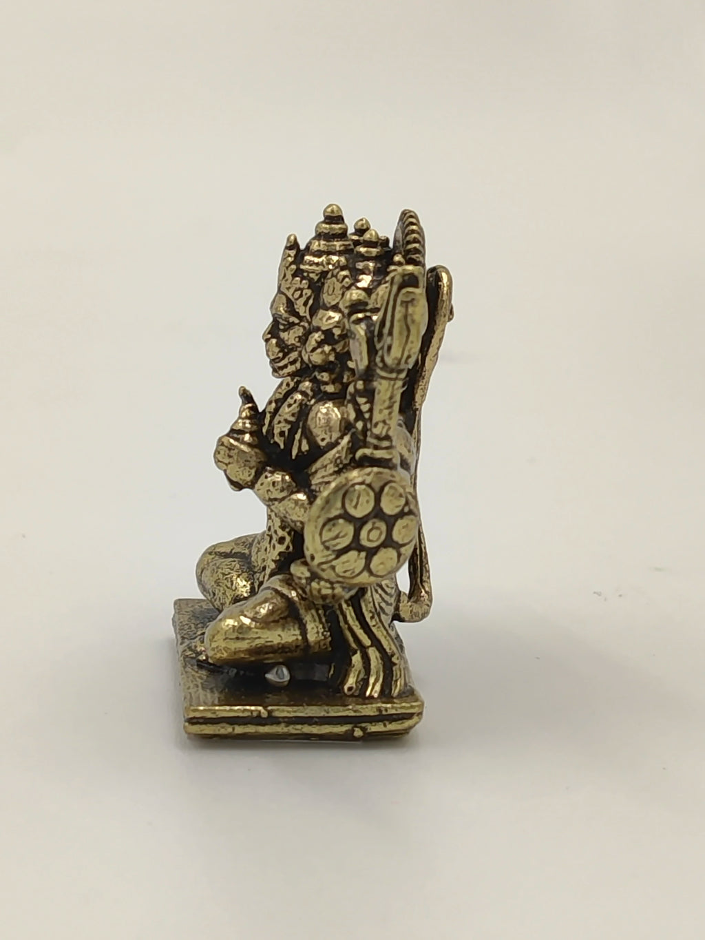 Side view of a mini brass Panchamukhi Hanuman statue sitting on a square base