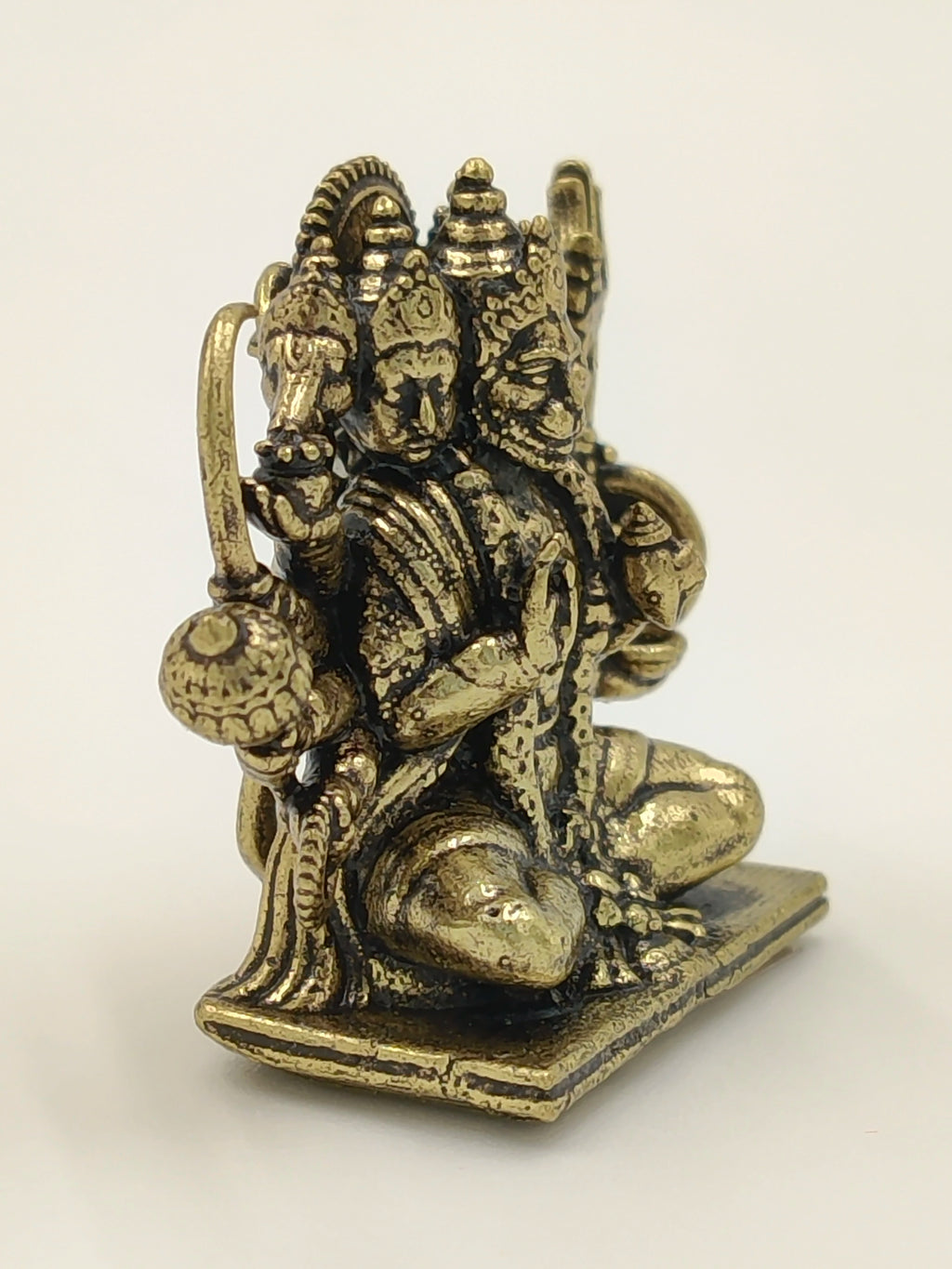 Mini brass Panchamukhi Hanuman sculpture seated on a rectangular base