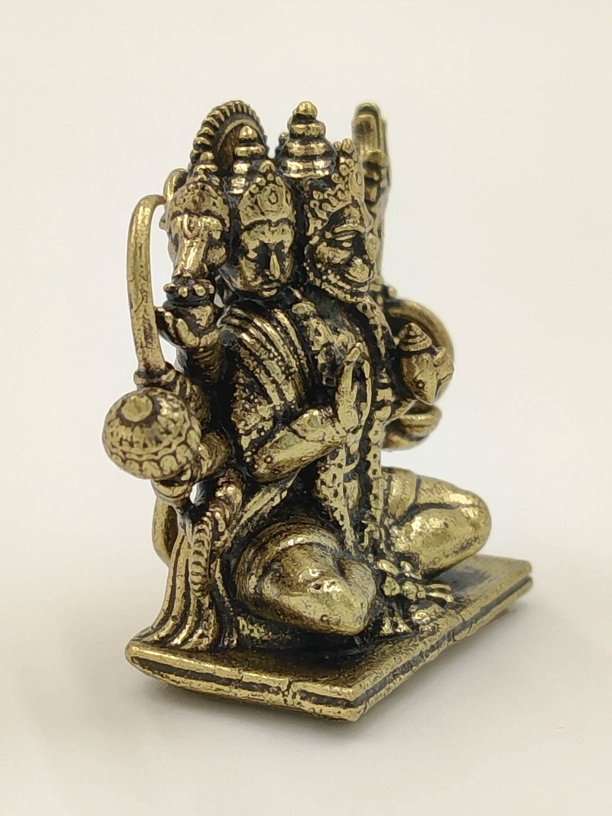 Mini brass Panchamukhi Hanuman sculpture seated on a rectangular base