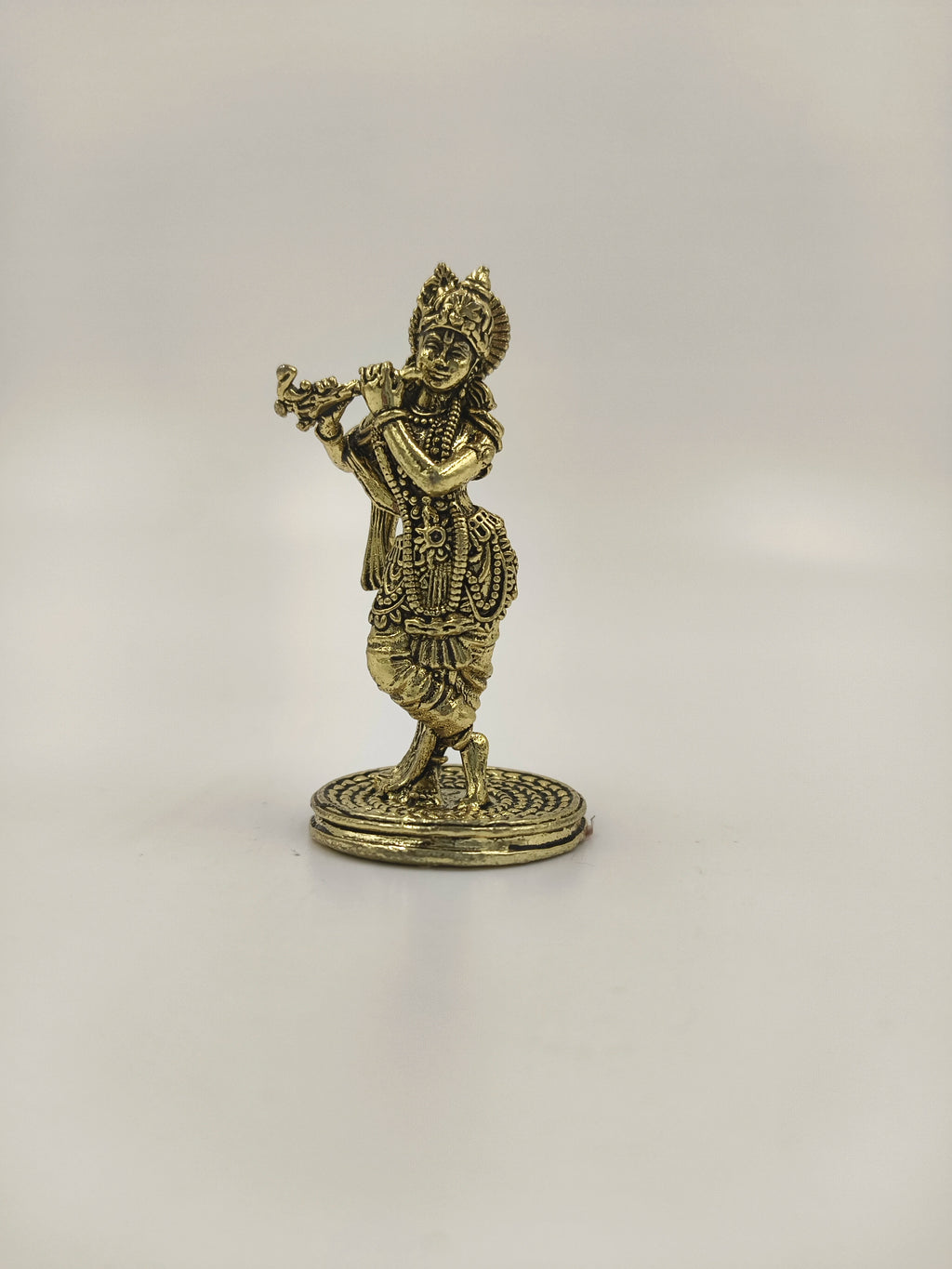 Mini brass statue of Krishna playing flute on round base