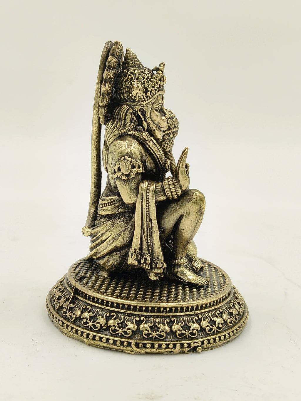 Small brass Hanuman sculpture with detailed carvings, side view