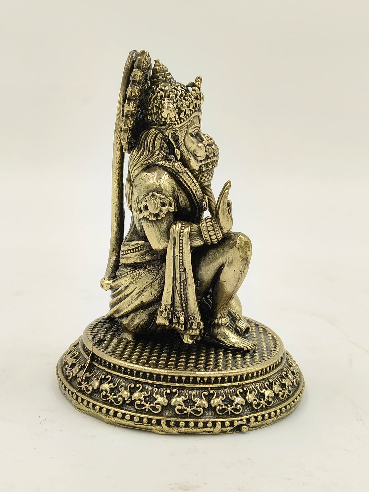 Small brass Hanuman sculpture with detailed carvings, side view