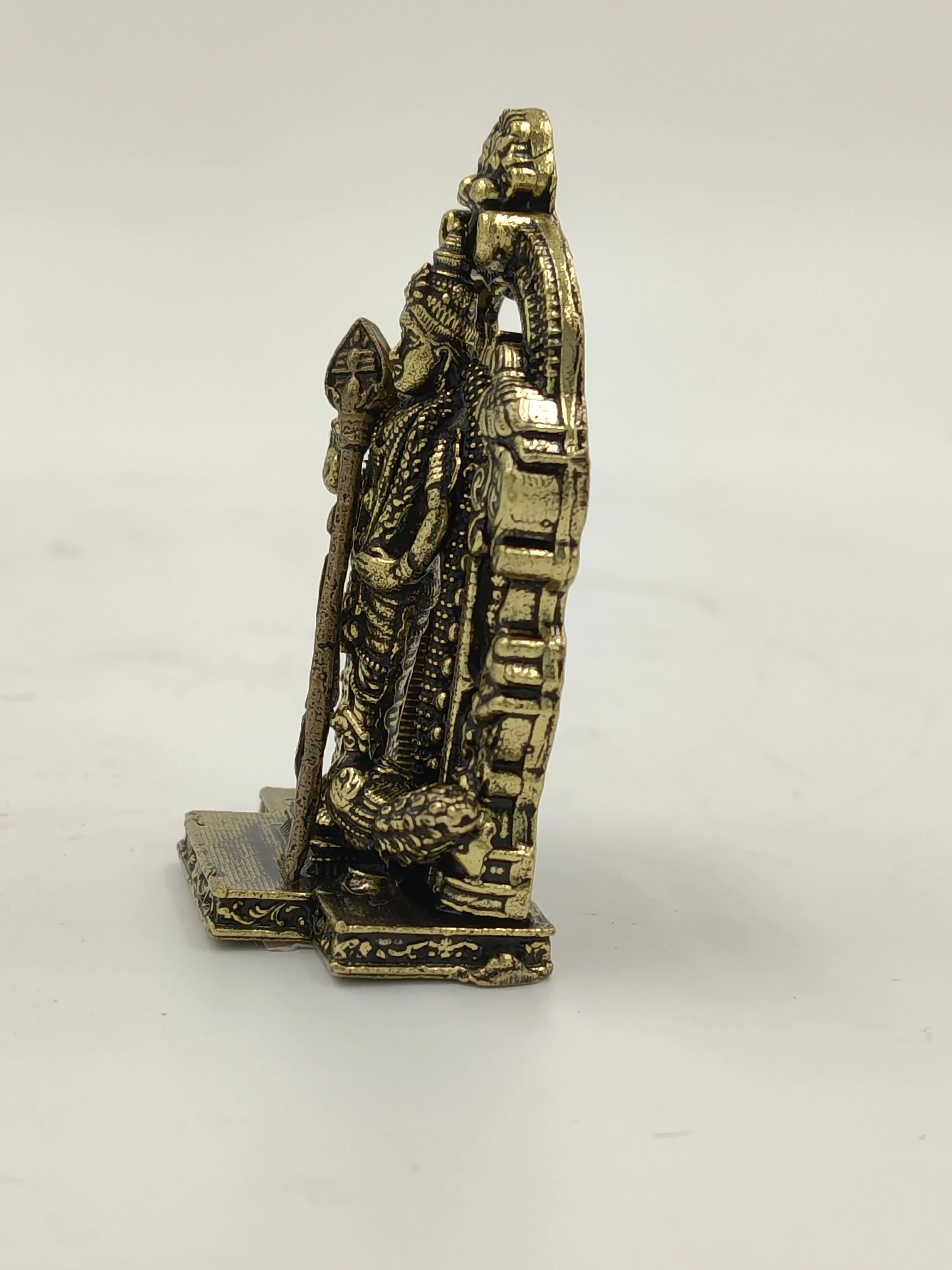 Side view of a small brass sculpture of deity Murgan standing with a spear