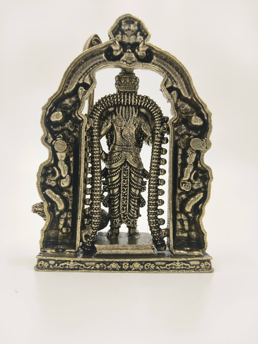 Back view of small brass Murgan sculpture with decorative arch frame