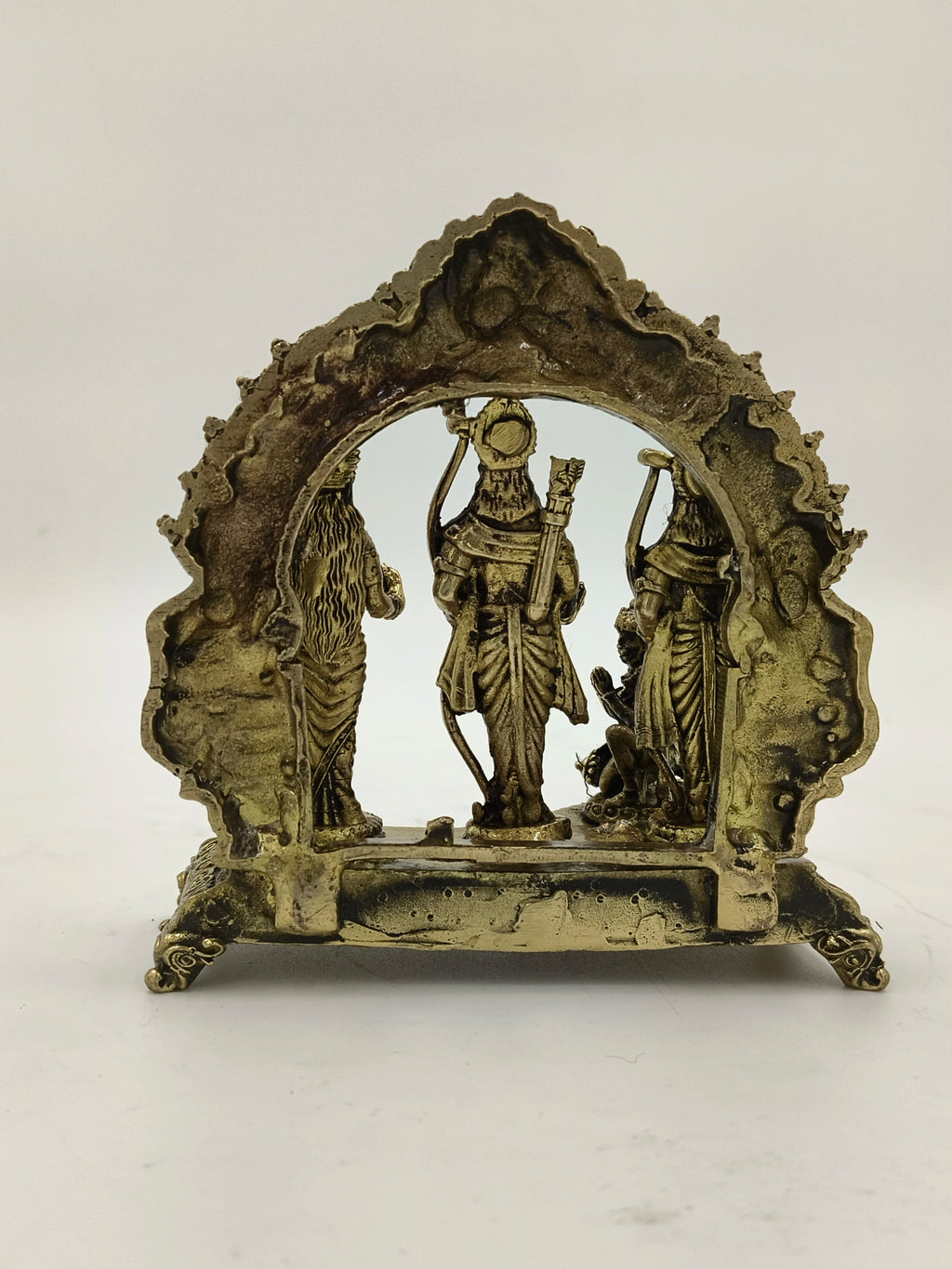 Back view of small brass Ram Parivar statue with ornate arch frame