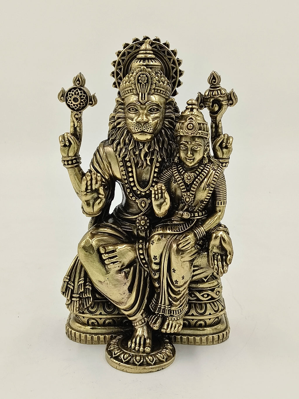 Brass sculpture of Narasimha deity with consort, seated on a decorative base