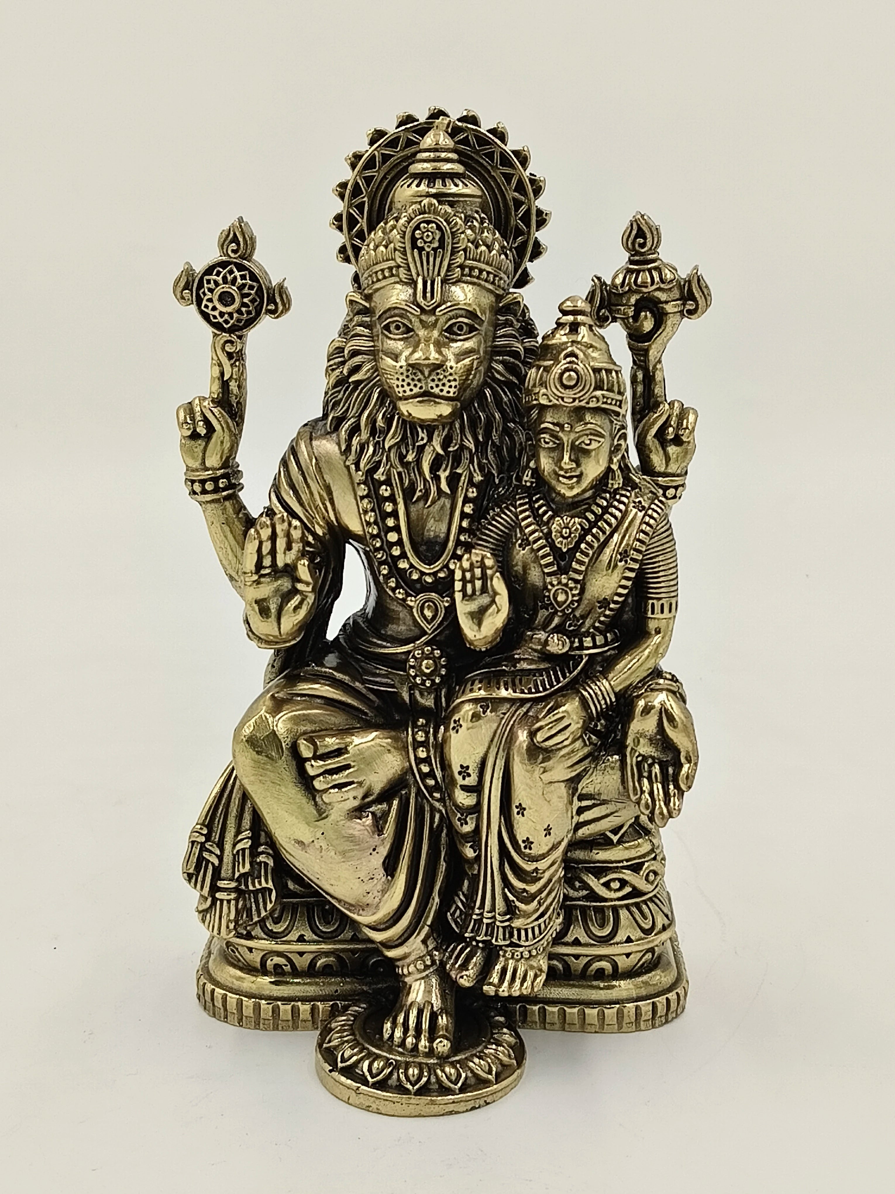 Brass sculpture of Narasimha deity with consort, seated on a decorative base