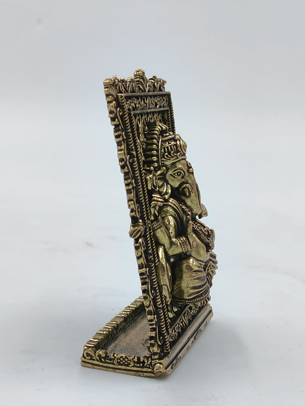 Side view of small brass Ganesh decorative panel with intricate frame