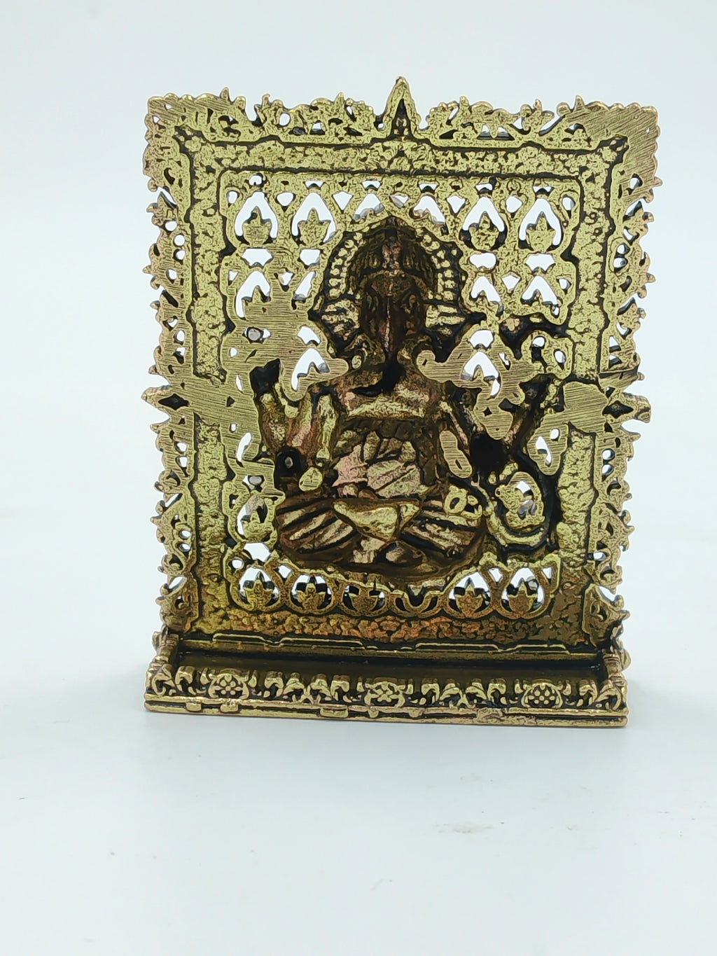 Small brass Ganesh panel sculpture with intricate decorative frame and base