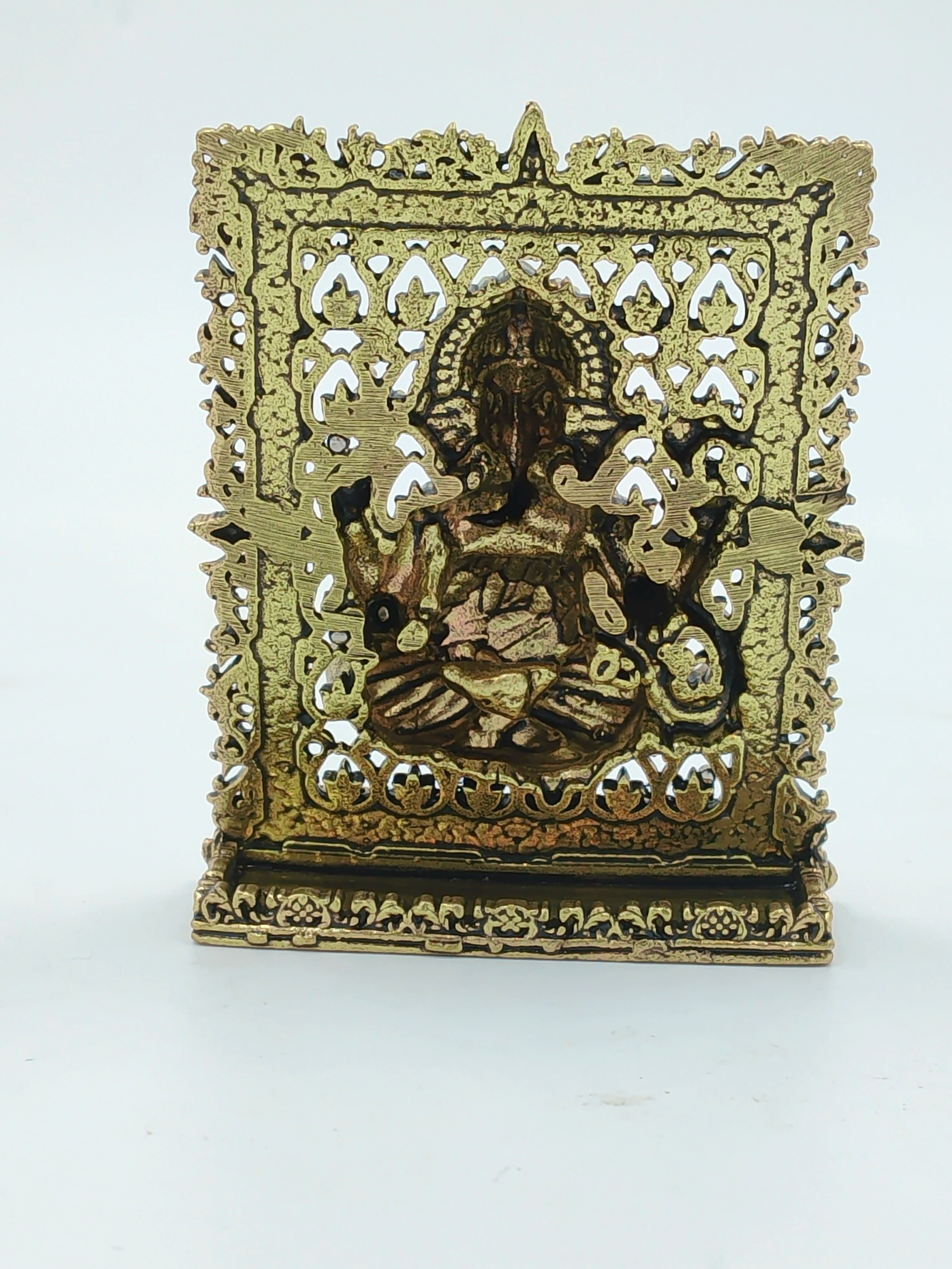 Small brass Ganesh panel sculpture with intricate decorative frame and base