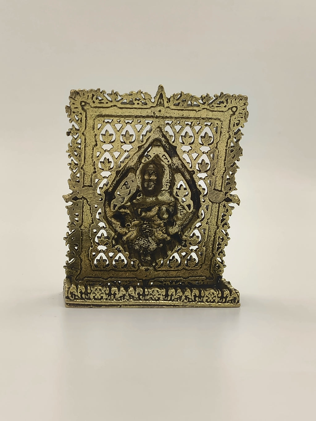 Small brass Murgan panel with intricate floral design and deity figure
