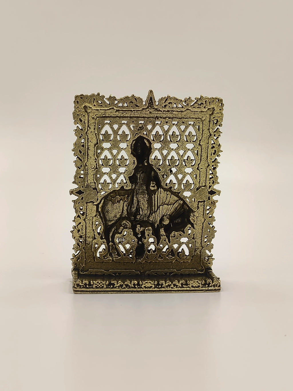 Small brass Krishna panel sculpture with ornate border and Krishna figure on bull