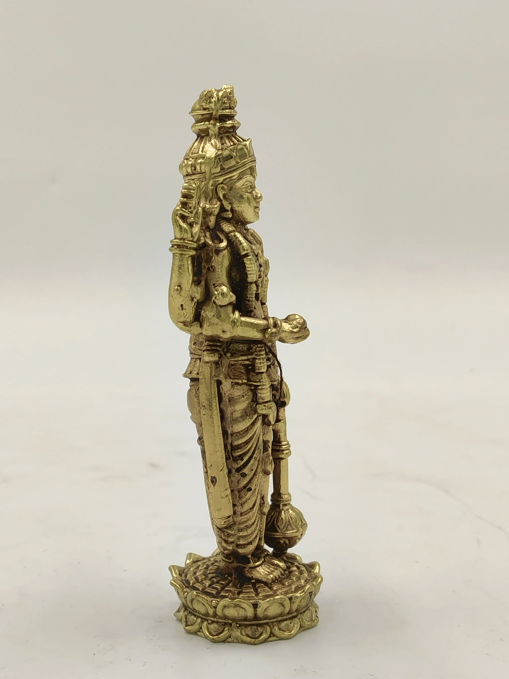 Small brass Vishnu statue standing on a lotus base, side view