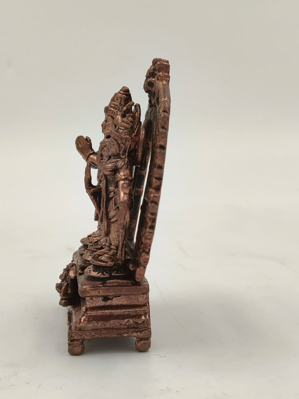 Side view of small copper Ram parivar brass sculpture on a pedestal