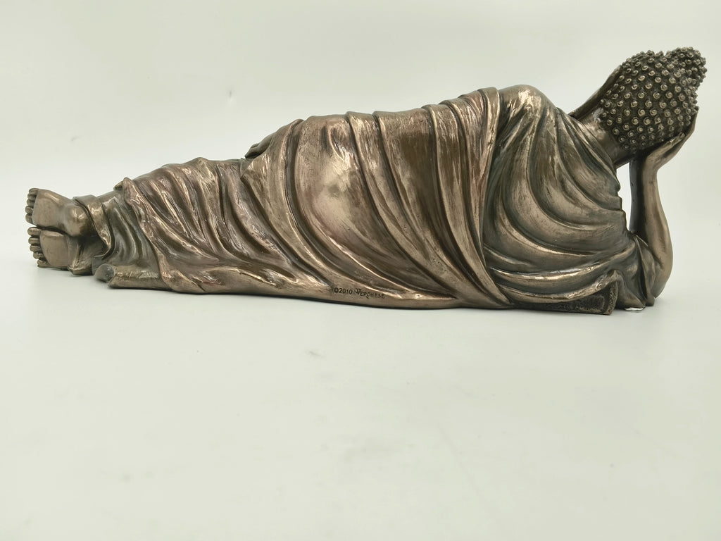 side view of polyresin reclining Buddha sculpture with detailed robe folds