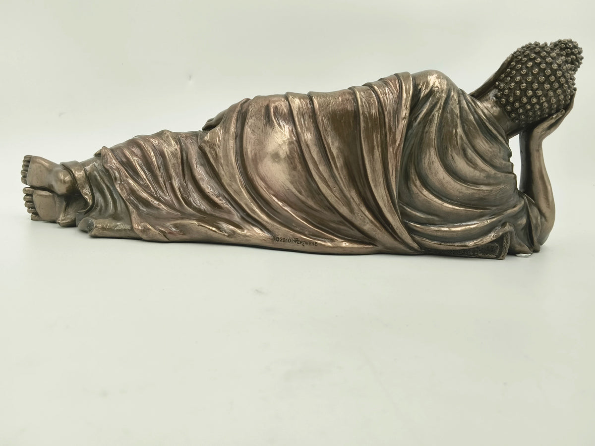 side view of polyresin reclining Buddha sculpture with detailed robe folds