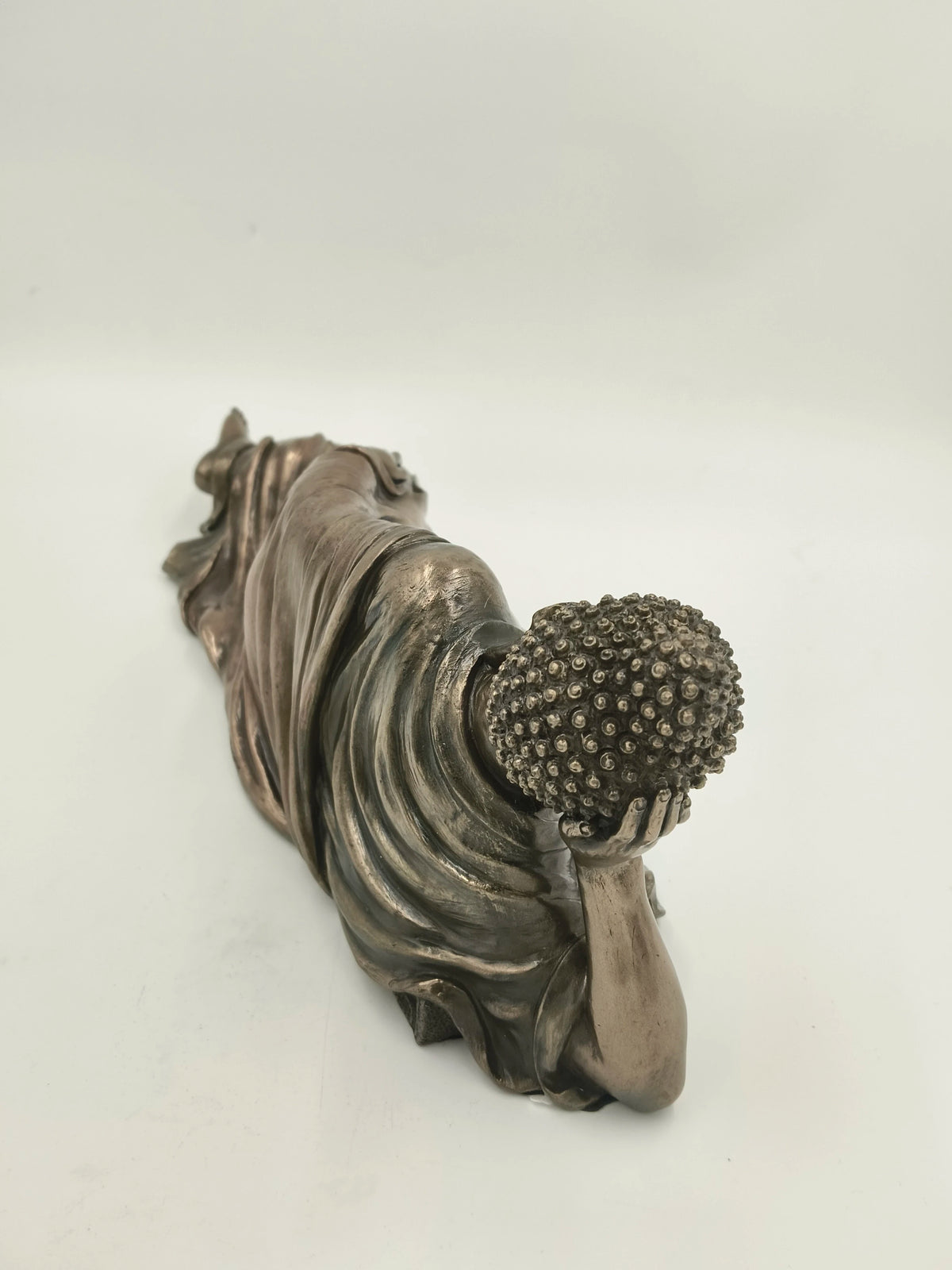 Polyresin medium-sized reclining Buddha sculpture resting on side with detailed hair