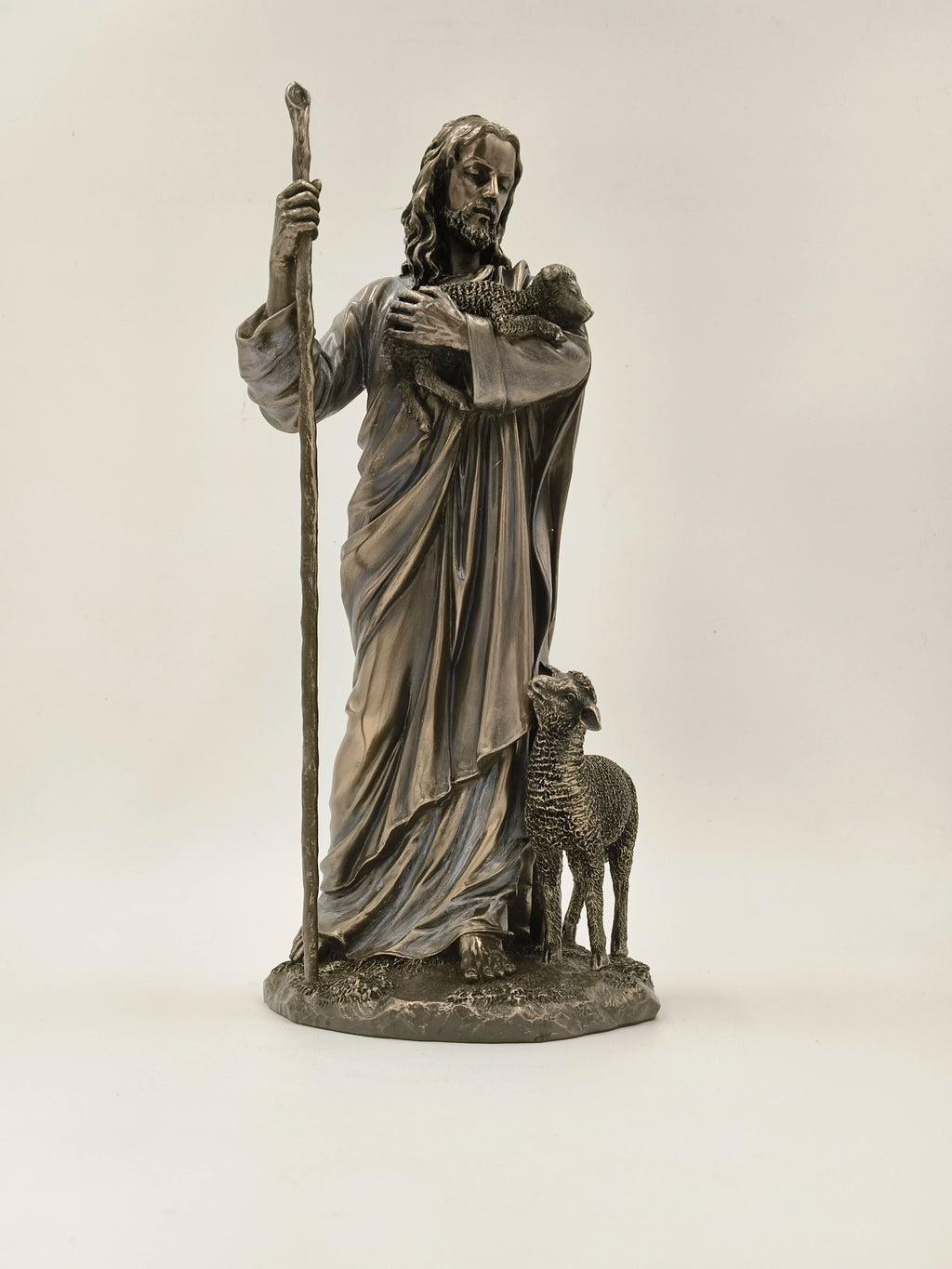 Polyresin sculpture of Jesus Christ holding a lamb and standing with a sheep