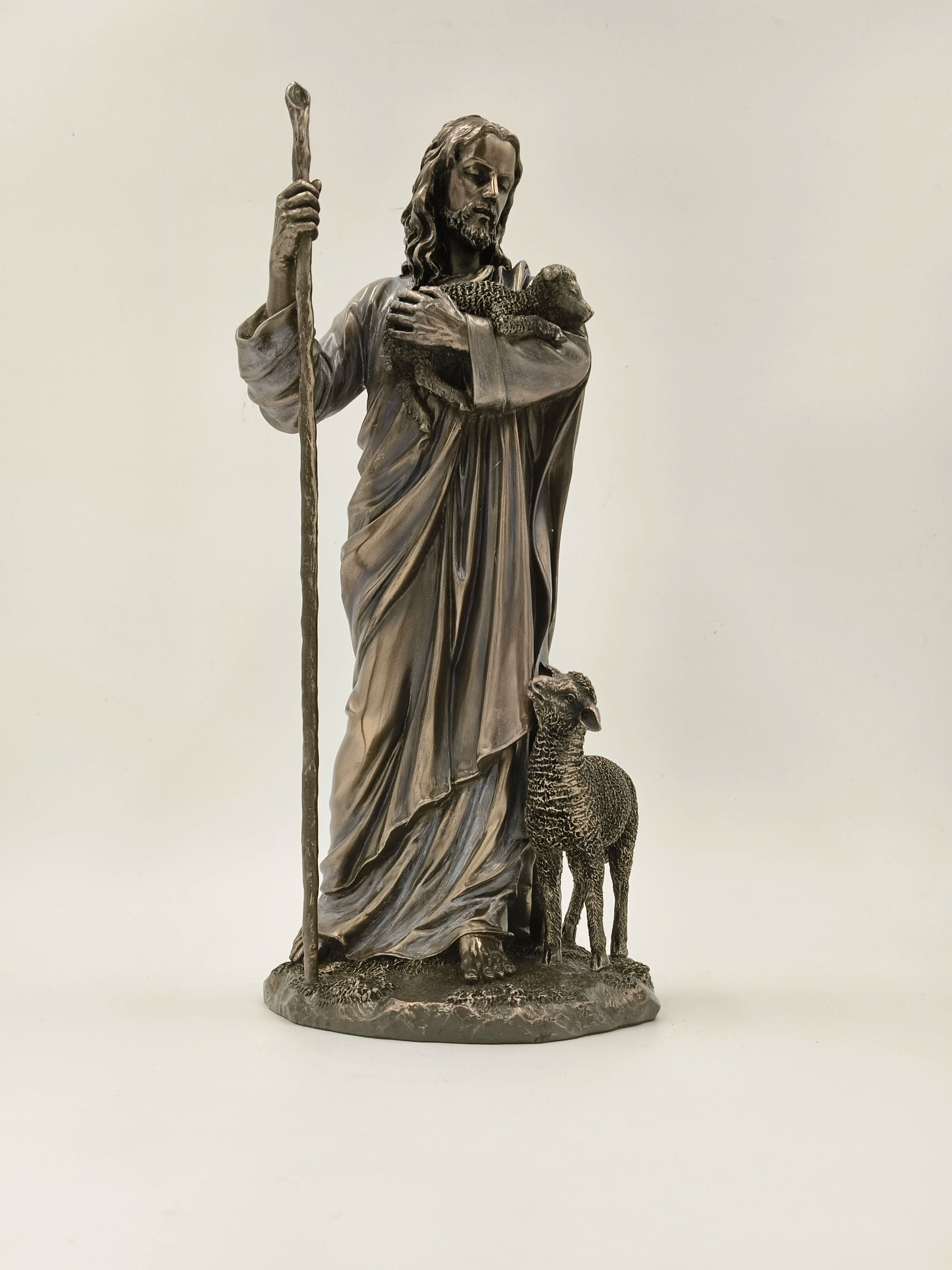 Polyresin sculpture of Jesus Christ holding a lamb and standing with a sheep