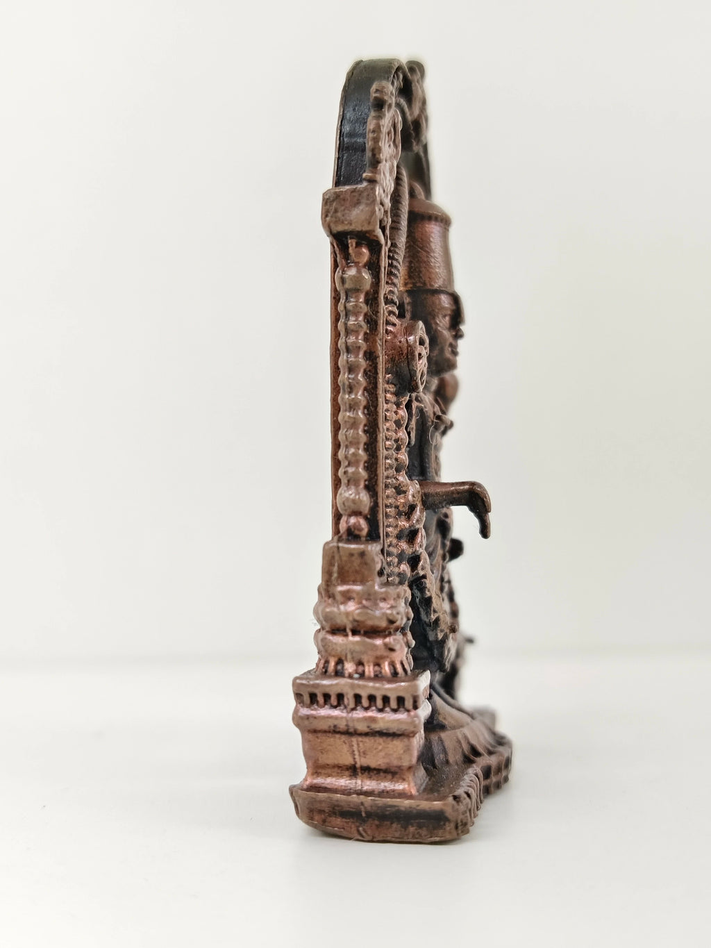 Side view of mini copper Balaji statue with arch and detailed base