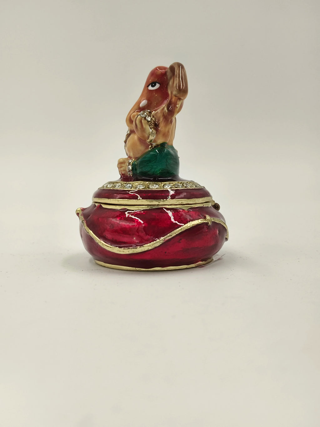 Mini brass Ganesh box with enamel finish in red and green, front view