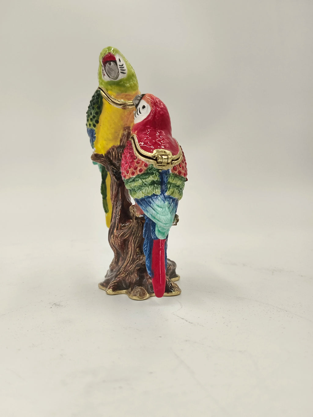 Brass enamel sculpture of two colorful parrots perched on a tree branch