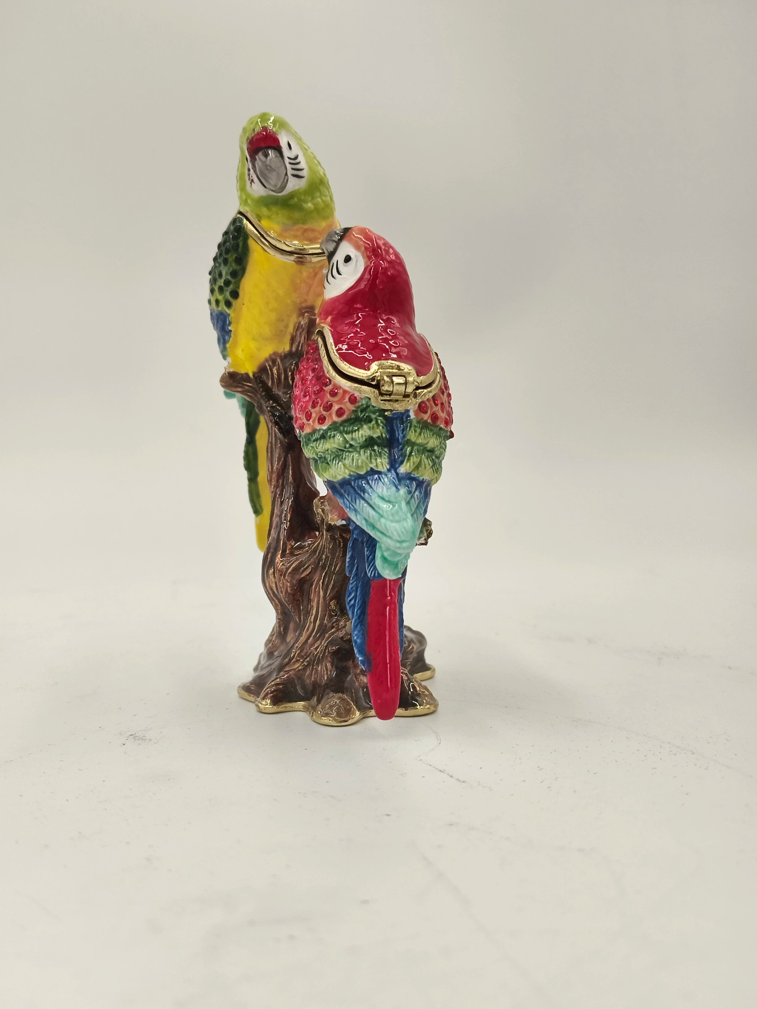 Brass enamel sculpture of two colorful parrots perched on a tree branch