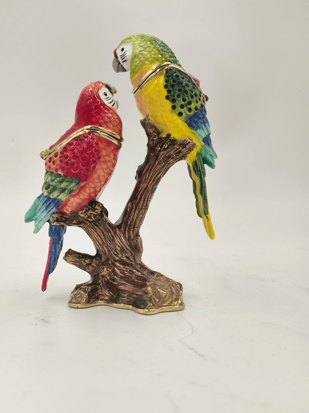 Brass enamel figurine of two colorful parrots perched on a brown branch