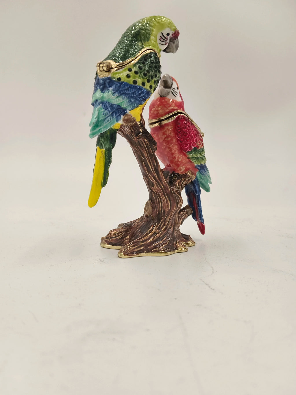 Brass enamel sculpture of two colorful parrots perched on a tree branch