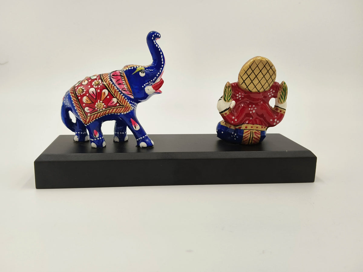 Small brass Ganesh statue with colorful painted elephant on black base