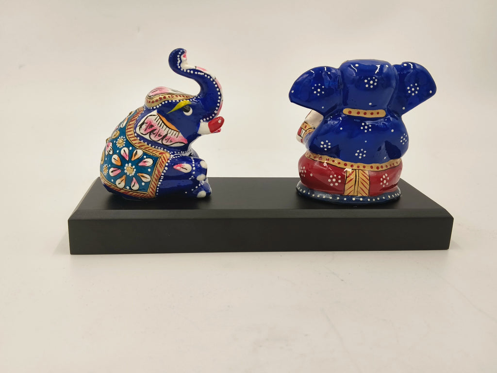 Blue and red brass Ganesh sculpture with elephant detail on black base